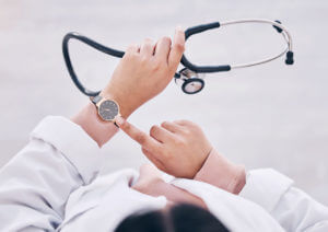 primary care doctor checking watch in hospital schedule