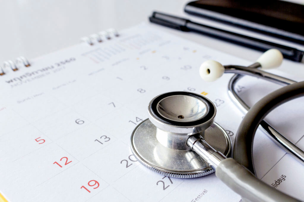 Stethoscope on calendar showing the benefits of weekend doctors.